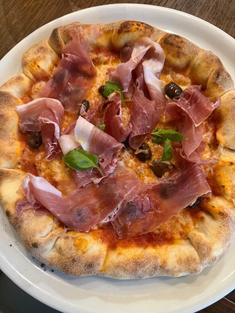 Pizza mit Parmaschinken und Basilikum